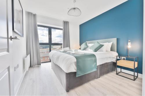 1 dormitorio con 1 cama grande y pared azul en Lovely 1 Bed Apartment Nightingale Quarter Derby en Derby