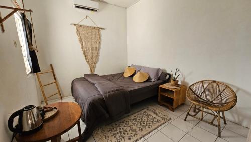 a bedroom with a bed and a table and a chair at Oke Baik Hostel in Yogyakarta