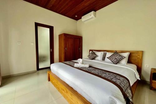 a bedroom with a large bed in a room at Belvilla 93823 Villa Gan Near Titi Batu Club Ubud in Ubud