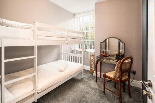 a bedroom with bunk beds with a mirror and a chair at Beautiful Basement Apartment in Bath