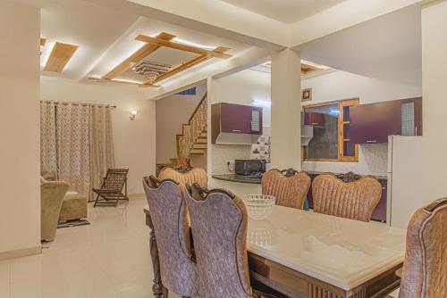 a dining room with a table and chairs at THE BLISSFUL BREEZE VILLA KASAULI BY EXOTIC STAYS in Kasauli