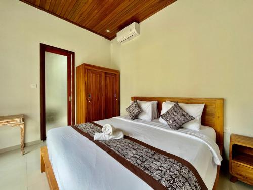 a bedroom with two beds and a doorway at Belvilla 93824 Villa Nesa Near Titi Batu Club Ubud in Ubud