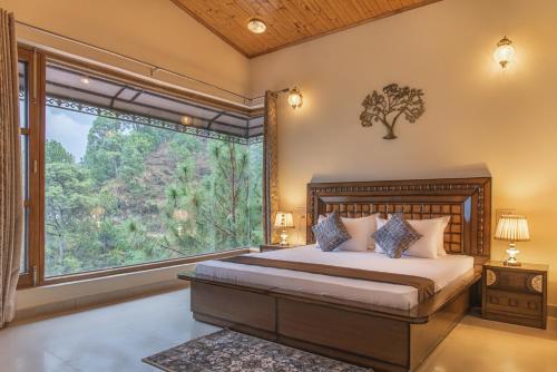 a bedroom with a bed and a large window at THE BLISSFUL BREEZE VILLA KASAULI BY EXOTIC STAYS in Kasauli
