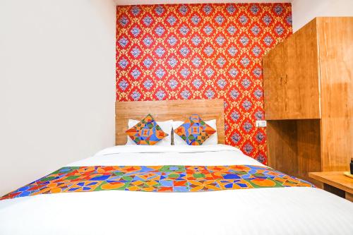 - une chambre avec un lit et une couette colorée dans l'établissement FabHotel Prime Lotus, à Vadodara