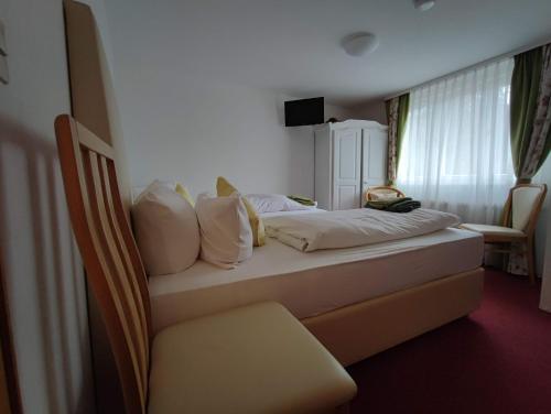 a bedroom with a bed and a chair in it at Room in Guest room - Pension Forelle - double room 01 in Forbach