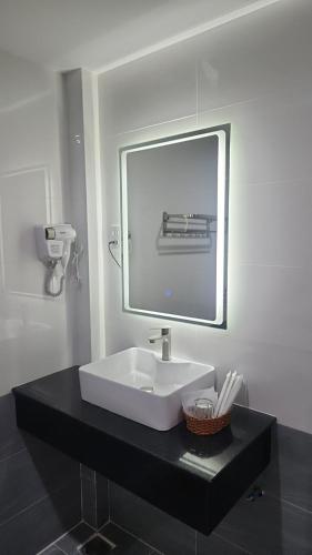 y baño con lavabo blanco y espejo. en HOTEL SONG TIÊN, en Trà Vinh