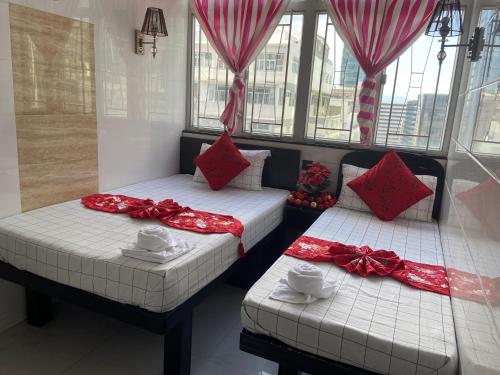 two beds in a room with red and white pillows at Australia Lounge in Hong Kong