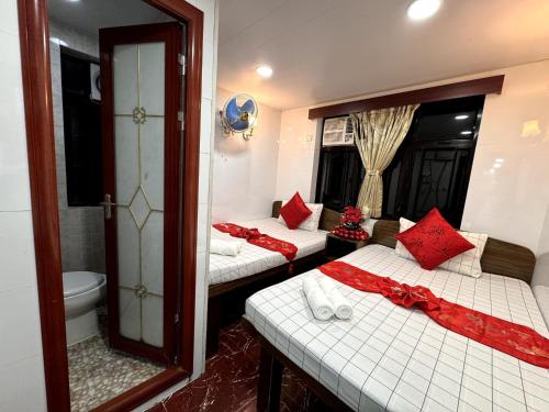 two beds with red pillows in a room at Australia Lounge in Hong Kong