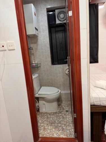 a bathroom with a toilet in a small room at Australia Lounge in Hong Kong