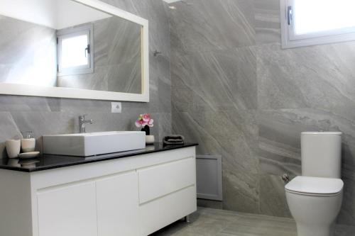 a bathroom with a white sink and a mirror at Luxury Villa Levanda in Ksamil