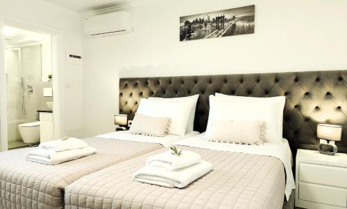 a bedroom with two beds with towels on them at Luxury Villa Levanda in Ksamil