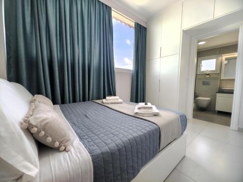 a bedroom with a bed with a window and a bathroom at Luxury Villa Levanda in Ksamil