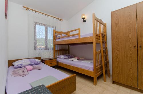 a bedroom with two bunk beds and a ladder at Apartments Lorena in Stomorska