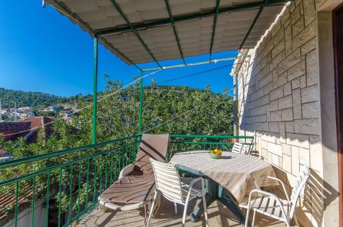 een terras met een tafel en stoelen op een balkon bij Apartments Lorena in Stomorska