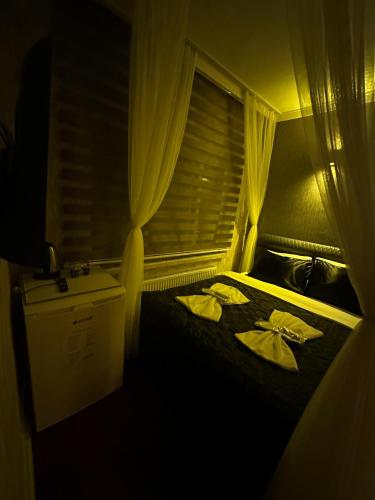 a bedroom with a bed with curtains and a window at ENJOY HOUSE BOUTİQE OTEL in Ankara
