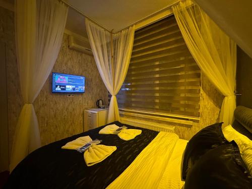 a bedroom with a bed with yellow towels on it at ENJOY HOUSE BOUTİQE OTEL in Ankara