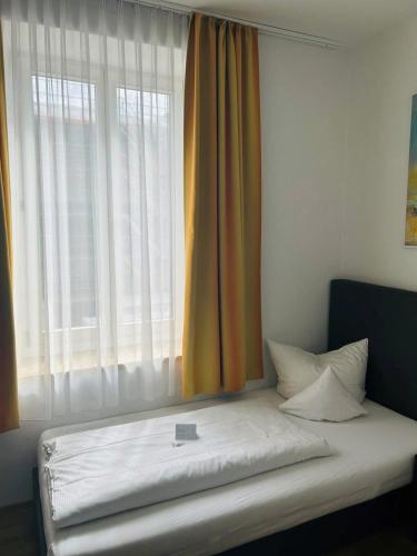 a bed in a room with a large window at Hotel Wendelstein in Rosenheim