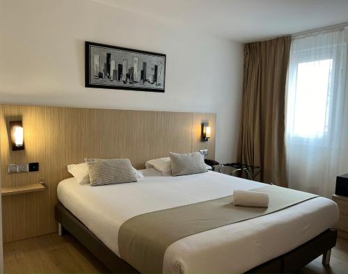 1 dormitorio con 1 cama grande en una habitación de hotel en Best Western Hotel & Spa Austria-La Terrasse en Saint-Étienne