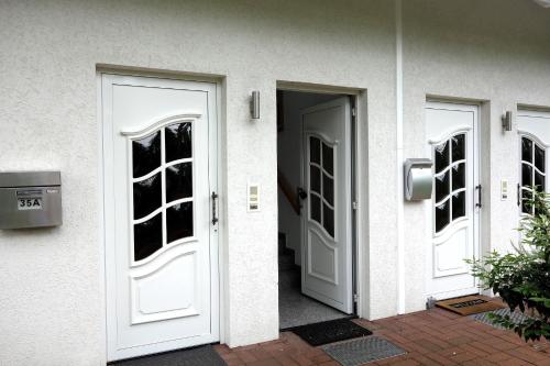 zwei weiße Türen an einem Gebäude mit in der Unterkunft Mina in Fehmarn