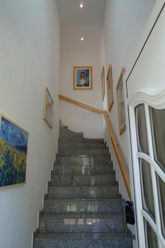 ein Treppenhaus in einem Gebäude mit Gemälden an den Wänden in der Unterkunft Mina in Fehmarn