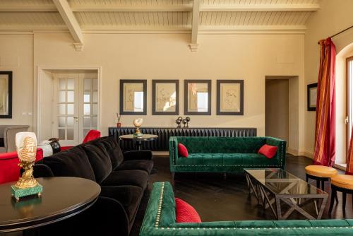 a living room with green couches and red chairs at Alvino Relais Mulino Contemporaneo in Matera