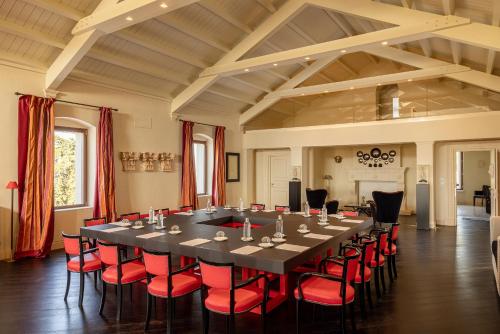 a large conference room with a long table and red chairs at Alvino Relais Mulino Contemporaneo in Matera