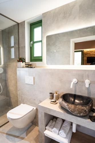 a bathroom with a sink and a toilet at Olvio Suites in Kardamili