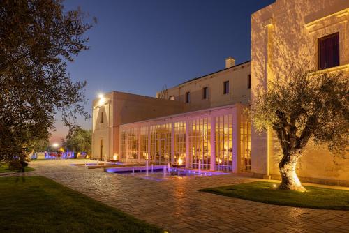 un edificio con un árbol delante de él por la noche en Alvino Relais Mulino Contemporaneo en Matera