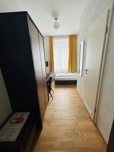 a hallway with a room with a bed and a door at Hotel Wendelstein in Rosenheim