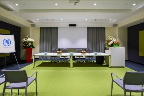 a meeting room with a large table and chairs at AN Hotel Milano Melegnano in Carpiano