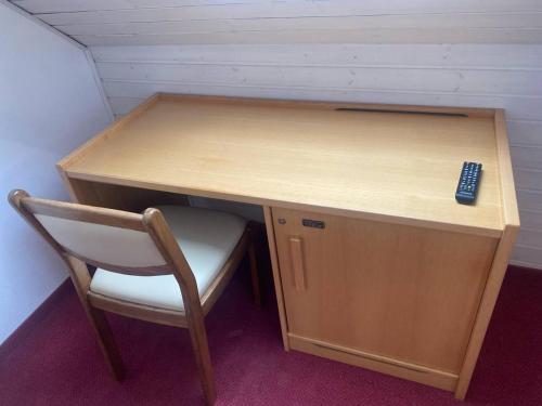 escritorio con silla y mando a distancia en Room in Guest room - Single room with shared bathroom and kitchen in Forbach en Forbach