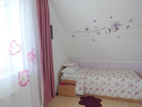 een slaapkamer met een bed en bloemen aan de muur bij Appartement in Burg Auf Fehmarn mit Terrasse, Garten und Grill in Fehmarn