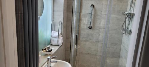 a bathroom with a shower and a sink at Victoria Park Lodge in Leamington Spa