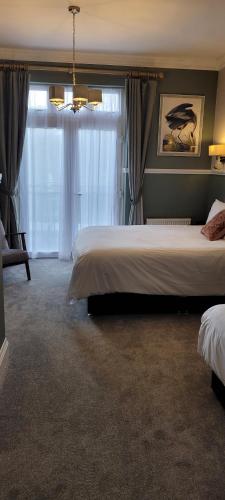 a bedroom with a large bed and a window at Victoria Park Lodge in Leamington Spa