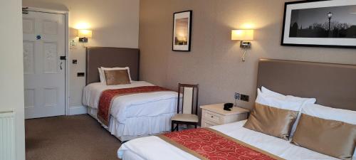 a hotel room with two beds and a bed sidx sidx sidx at Victoria Park Lodge in Leamington Spa