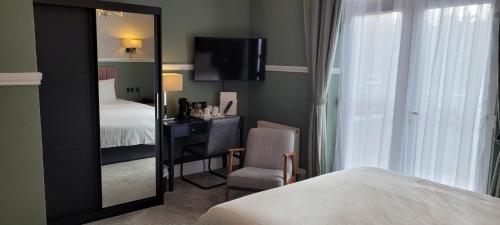 a hotel room with a bed and a mirror at Victoria Park Lodge in Leamington Spa