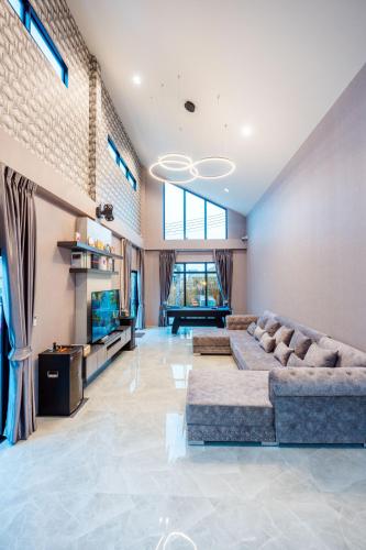 a large living room with a couch and a television at BoHome Pool Villa Cha-am in Ban Sa