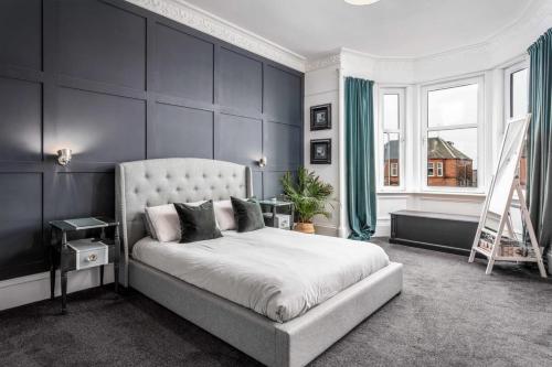 a bedroom with a large bed with blue walls at 58 Prestwick Road in Ayr