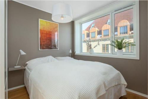 1 dormitorio con cama blanca y ventana en Ferienwohnung für 2 Personen ca 35 qm in Haugesund, Südnorwegen en Haugesund