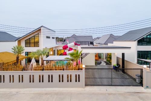 a house with a fence in front of it at BoHome Pool Villa Cha-am in Ban Sa