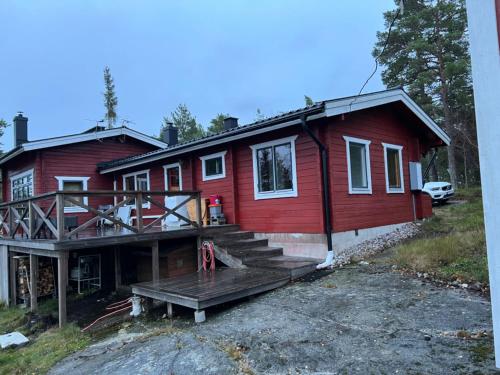 ein rotes Haus mit einer Veranda und einer Terrasse in der Unterkunft Värmdö in Värmdö