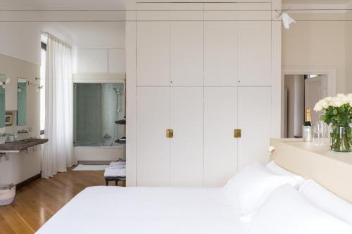 a white bedroom with a bed and a bathroom at Villa Noseda in Moltrasio
