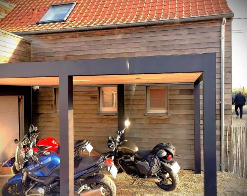 twee motorfietsen geparkeerd voor een huis bij Schön renoviertes Ferienhaus für acht Personen in idyllischer Lage, mit Terrasse und Garten in Ellezelles