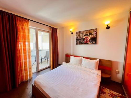 a bedroom with a bed and a large window at NeverSea Flat in Constanţa