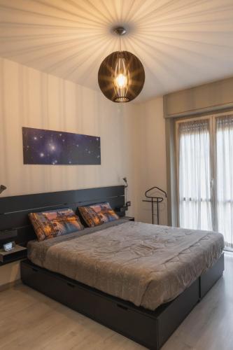 a bedroom with a large bed and a chandelier at Appartamento moderno San Siro in Milan
