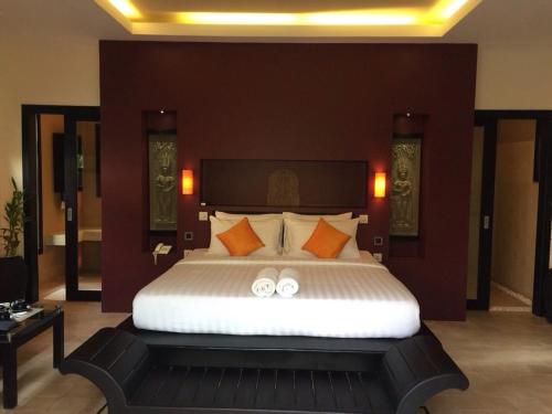a bedroom with a large bed with two white wedding rings at Villa Jaya in Siem Reap