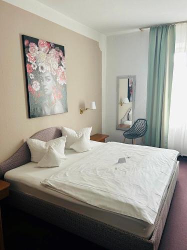 a bedroom with a large white bed in a room at Hotel Wendelstein in Rosenheim
