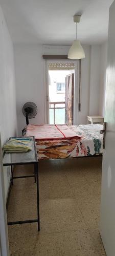 巴塞隆納的住宿－Habitación espaciosa con cama doble，一间卧室配有一张床、一张桌子和一个窗户。