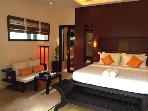 a bedroom with a large bed and a couch at Villa Jaya in Phumĭ Réach Born (2)