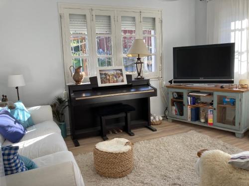 sala de estar con piano y TV en Ferienhaus für 3 Personen 1 Kind ca 86 qm in La Franca, Costa Verde Spanien Küste von Asturien, en La Franca